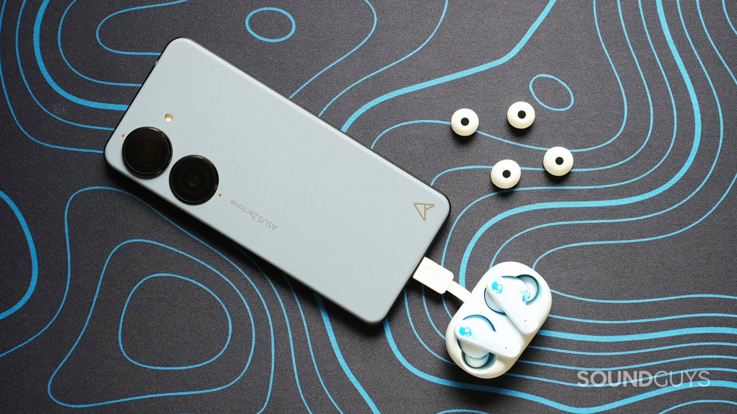 skullcandy ecobuds plugged into phone with ear tips on table