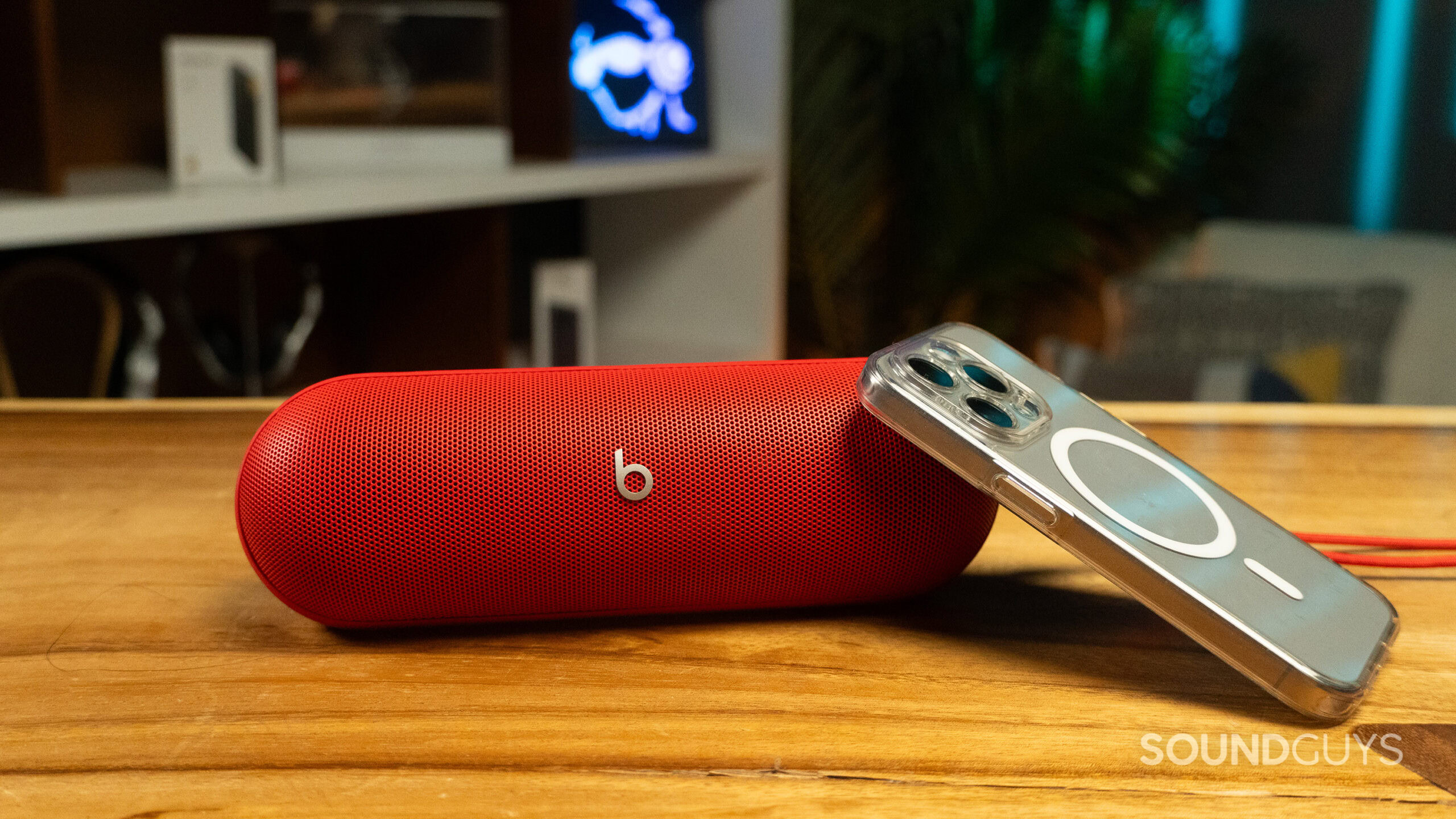 The Beats Pill next to an iPhone 15 Pro.