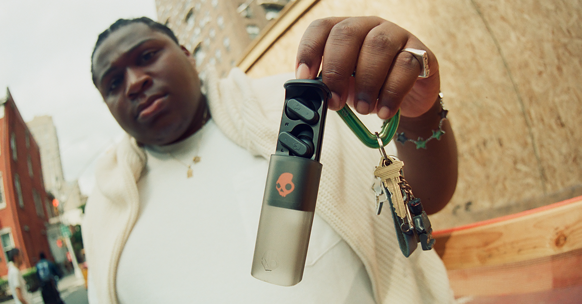 A man holds the Skullcandy Dime Evo earbuds.