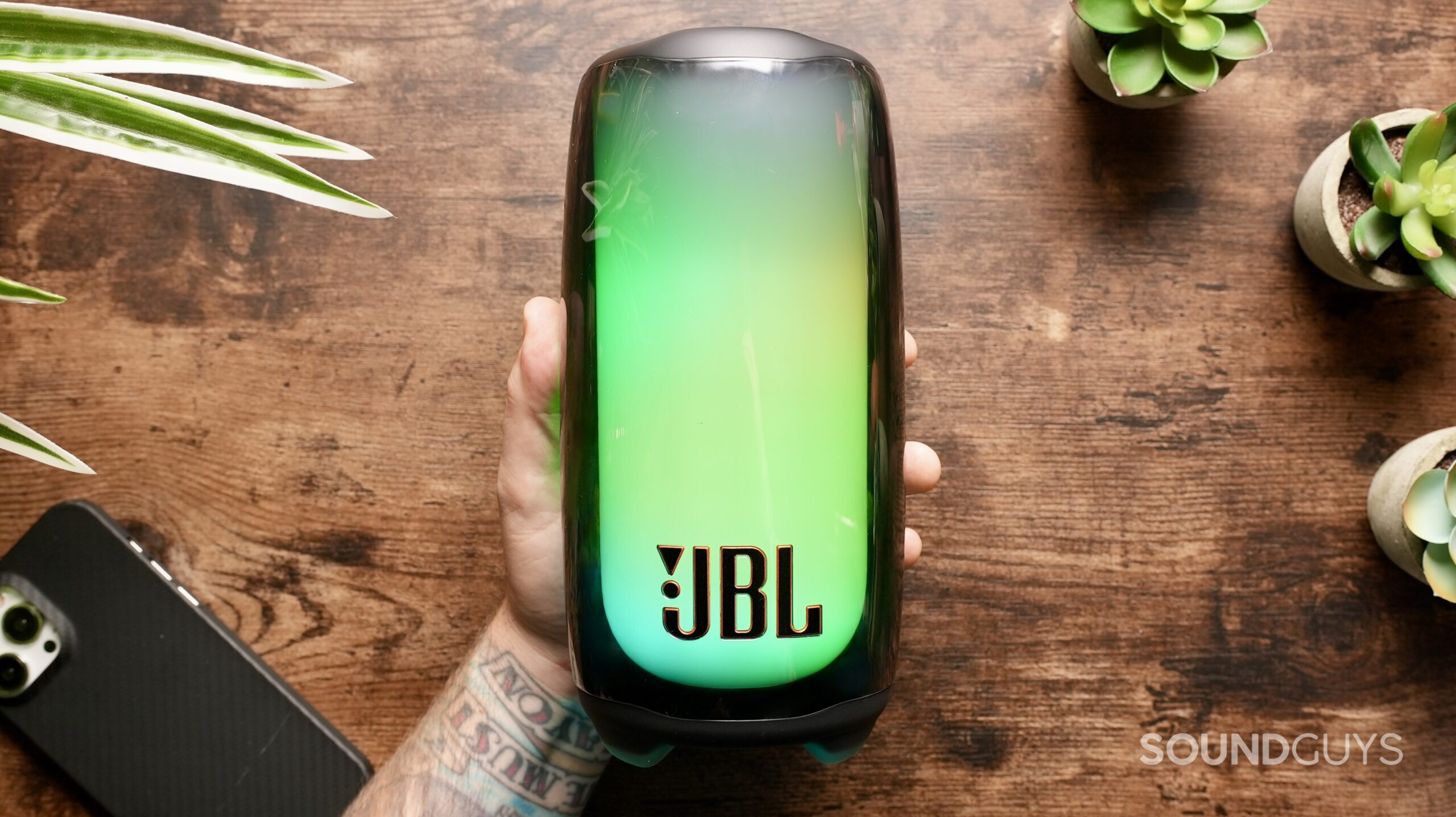 A hand holds the JBL Pulse 5.