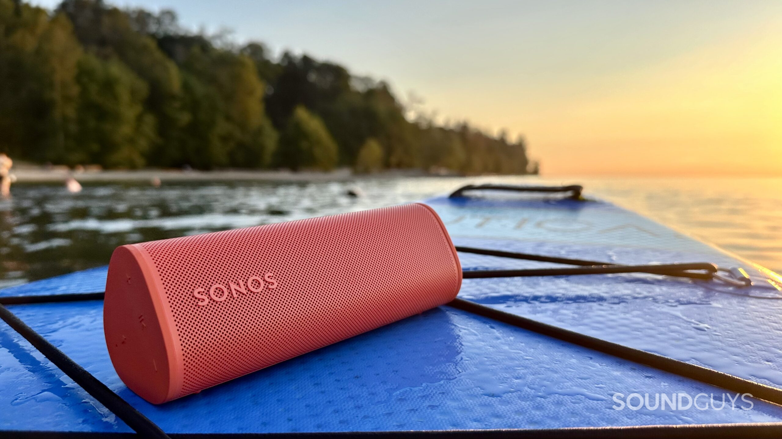 Sonos Roam 2 speaker placed on a paddle board looking towards the sunset