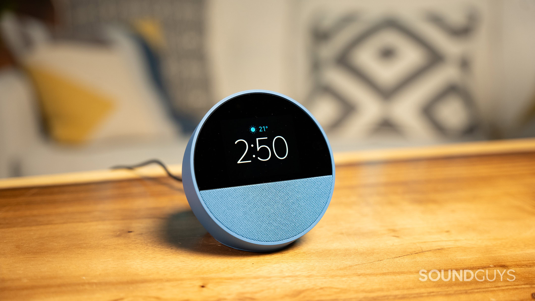 Amazon Echo Spot (2024) on a wood table in front of a couch.