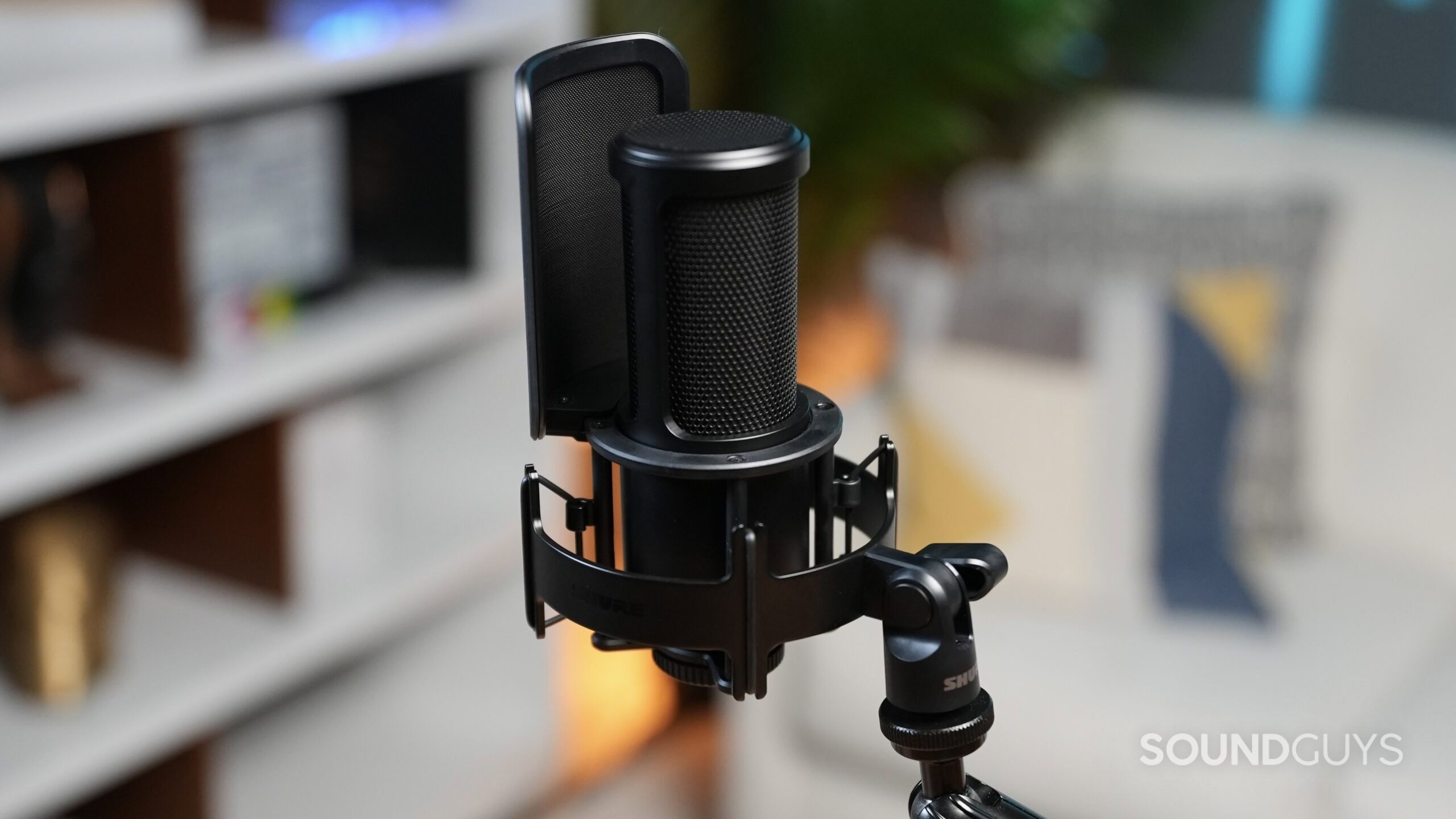 A Shure SM4 microphone with windscreen and shock mount on a boom arm.