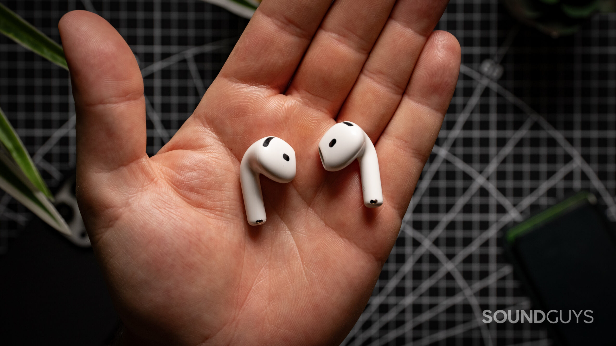 AirPods 4 with Active Noise Cancellation earbuds in the palm of a hand.