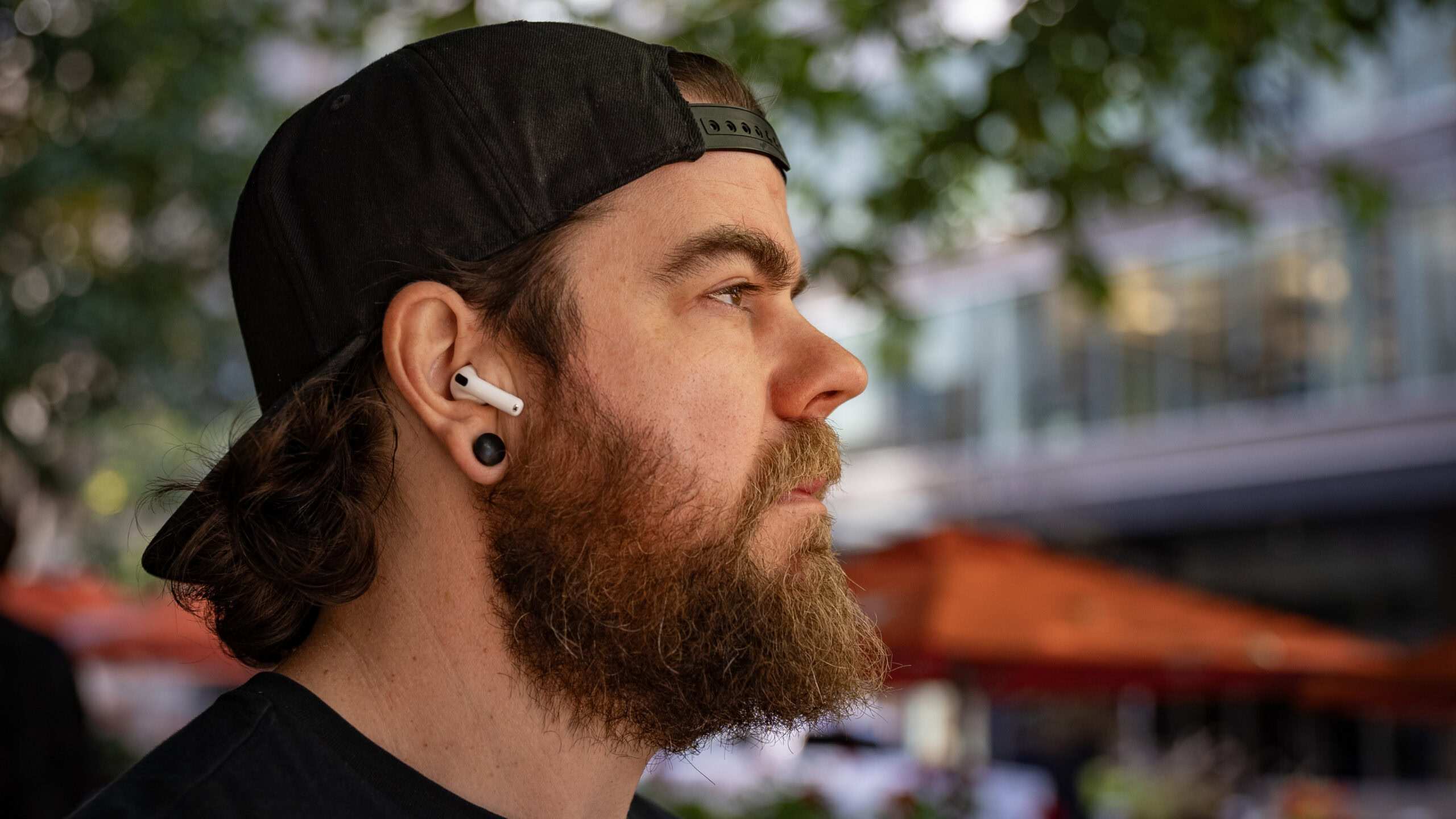 A man wearing AirPods 4 outside.