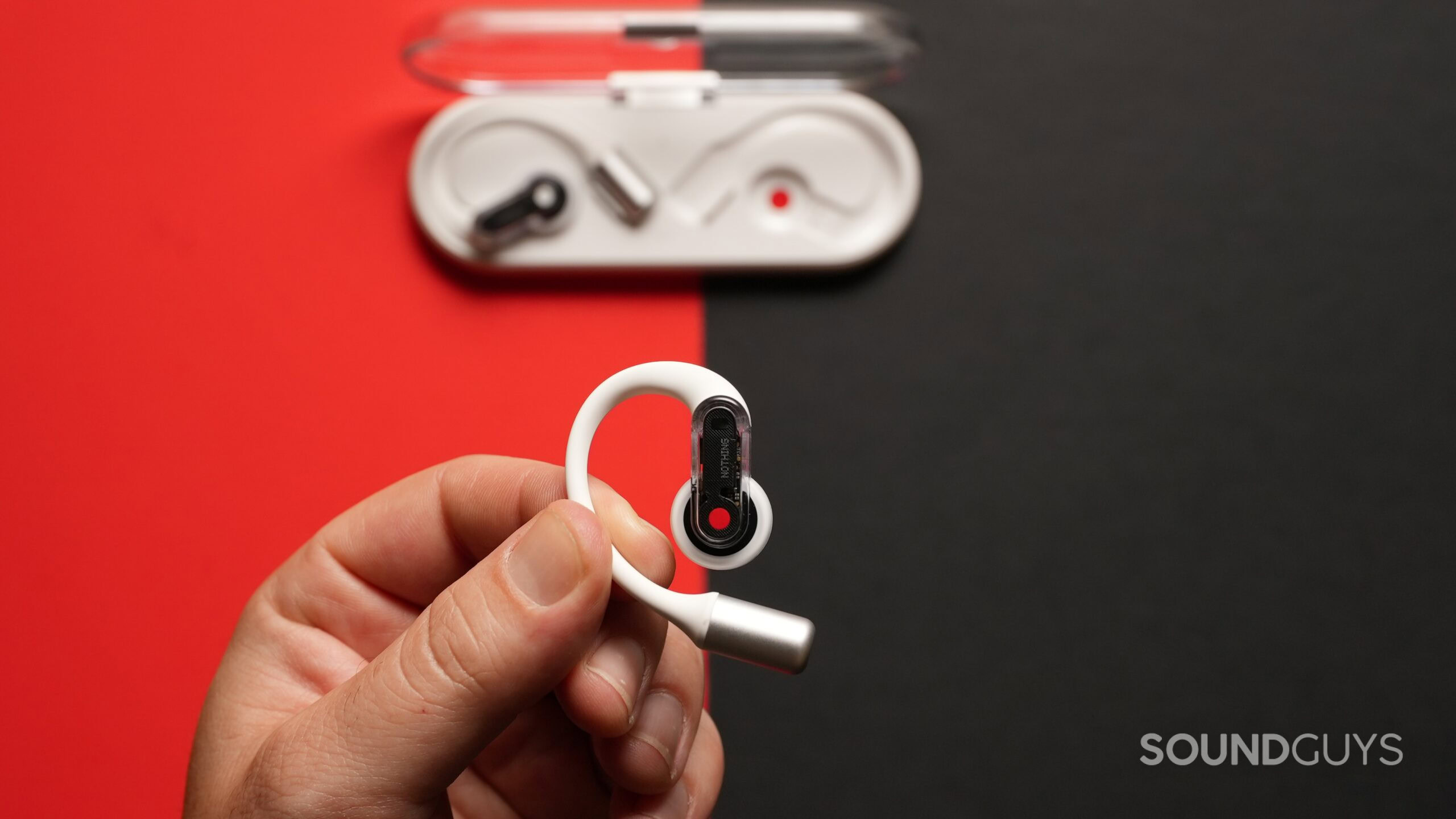 Top down photo of a hand holding a Nothing Ear (Open) earbud.