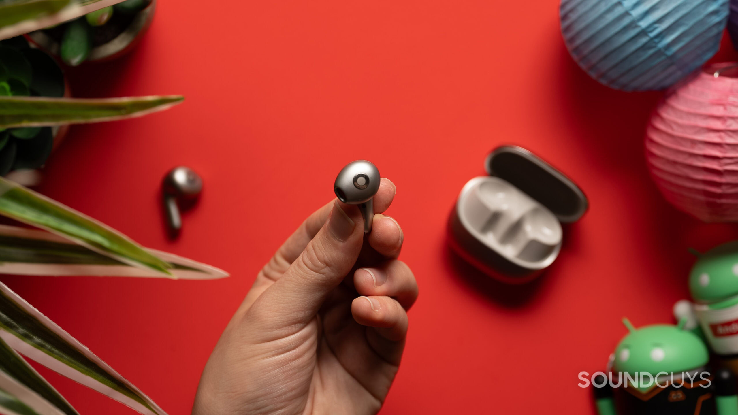 A hand holds the Xiaomi Buds 5 earbud.