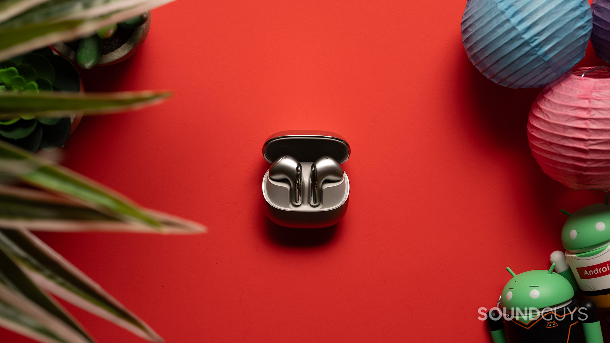 Xiaomi Buds 5 in case on a table.