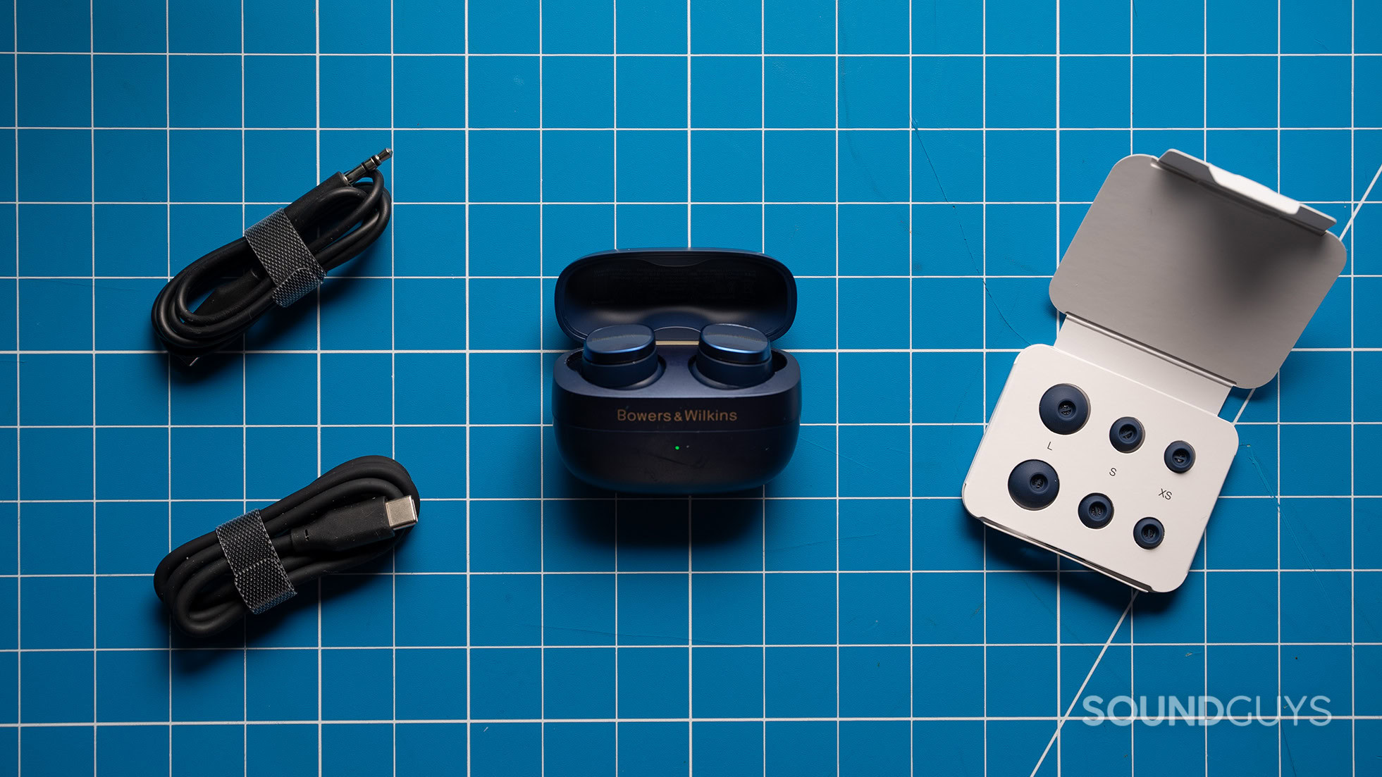 Bowers &amp; Wilkins Pi8 earbuds and accessories on a table. 