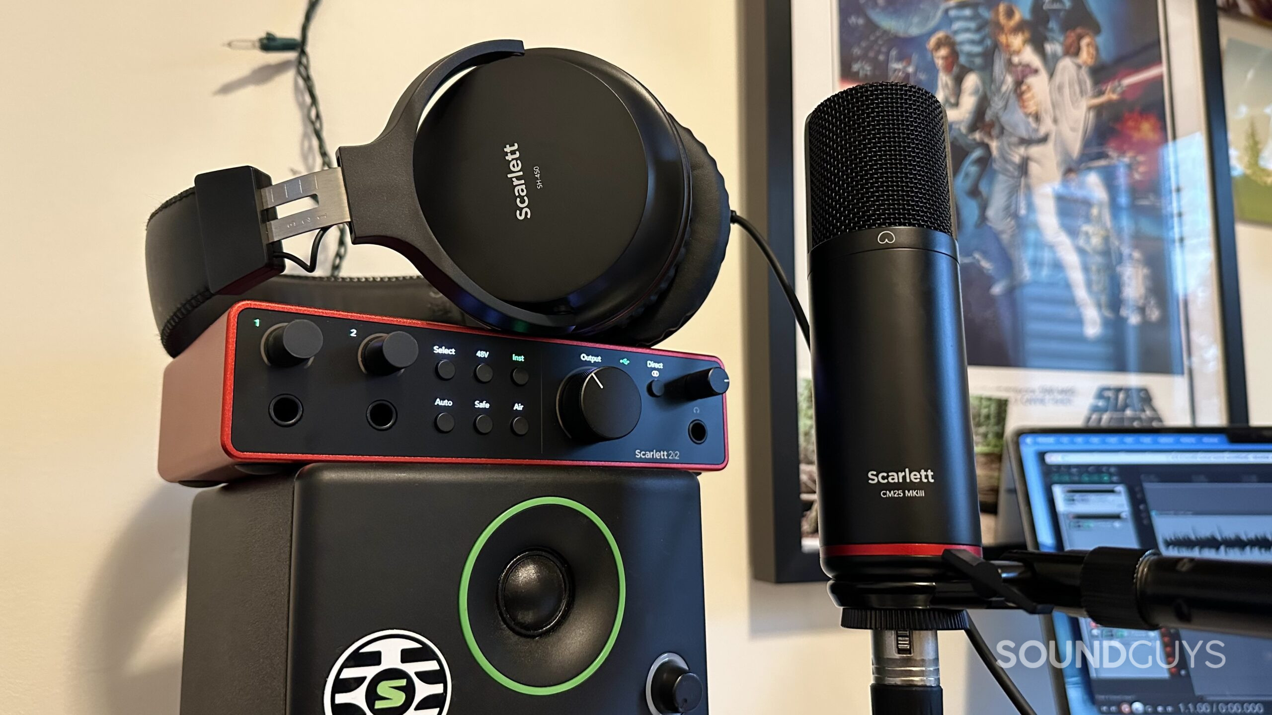 A photo of the Focusrite Scarlett 2i2 interface, SH-450 headphones, and the CM25 MKIII microphone in a home studio.