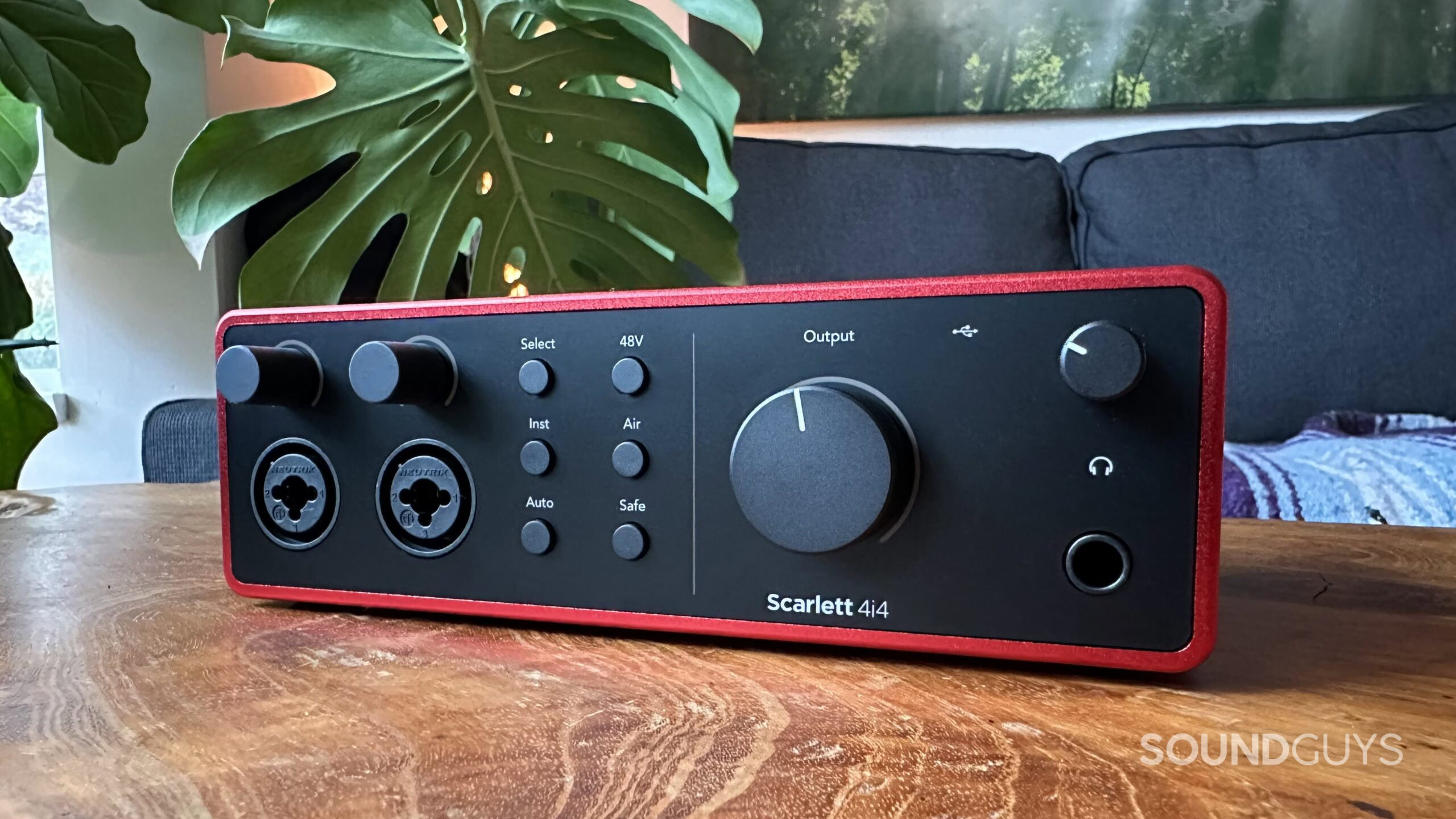 A Focusrite Scarlett 4i4 sitting on a coffee table, showing it's front panel.