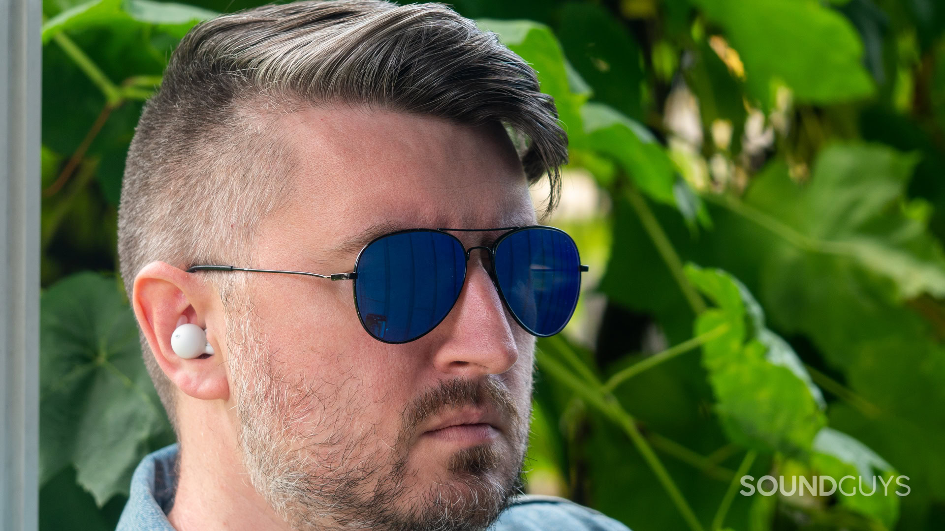 A photo of a man wearing the Sony LinkBuds Open, aviators.