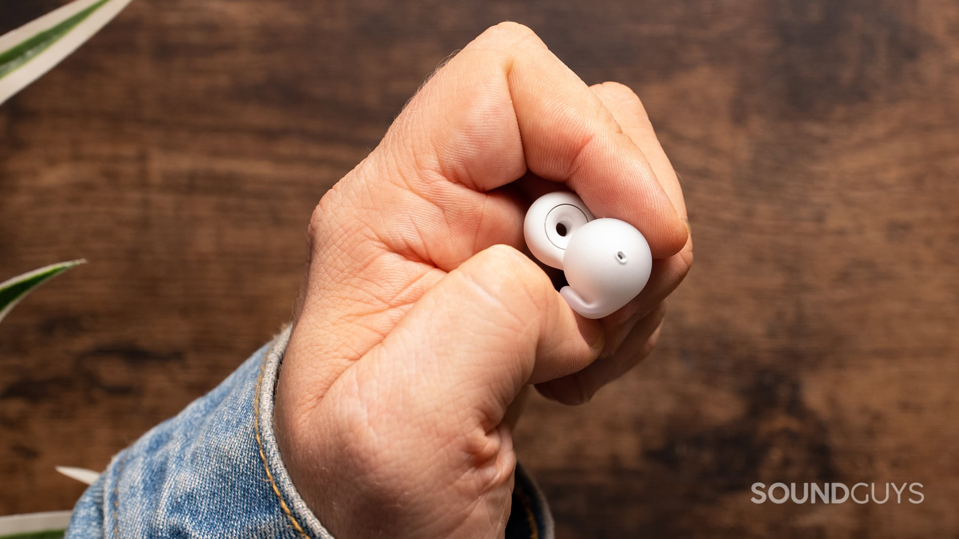 A photo of a hand crushing the fin of the Sony LinkBuds Open