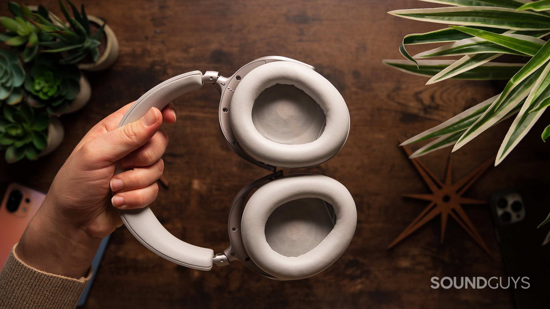 A hand holding the Beyerdynamic AVENTHO 300 headphones displaying the ear cups. 