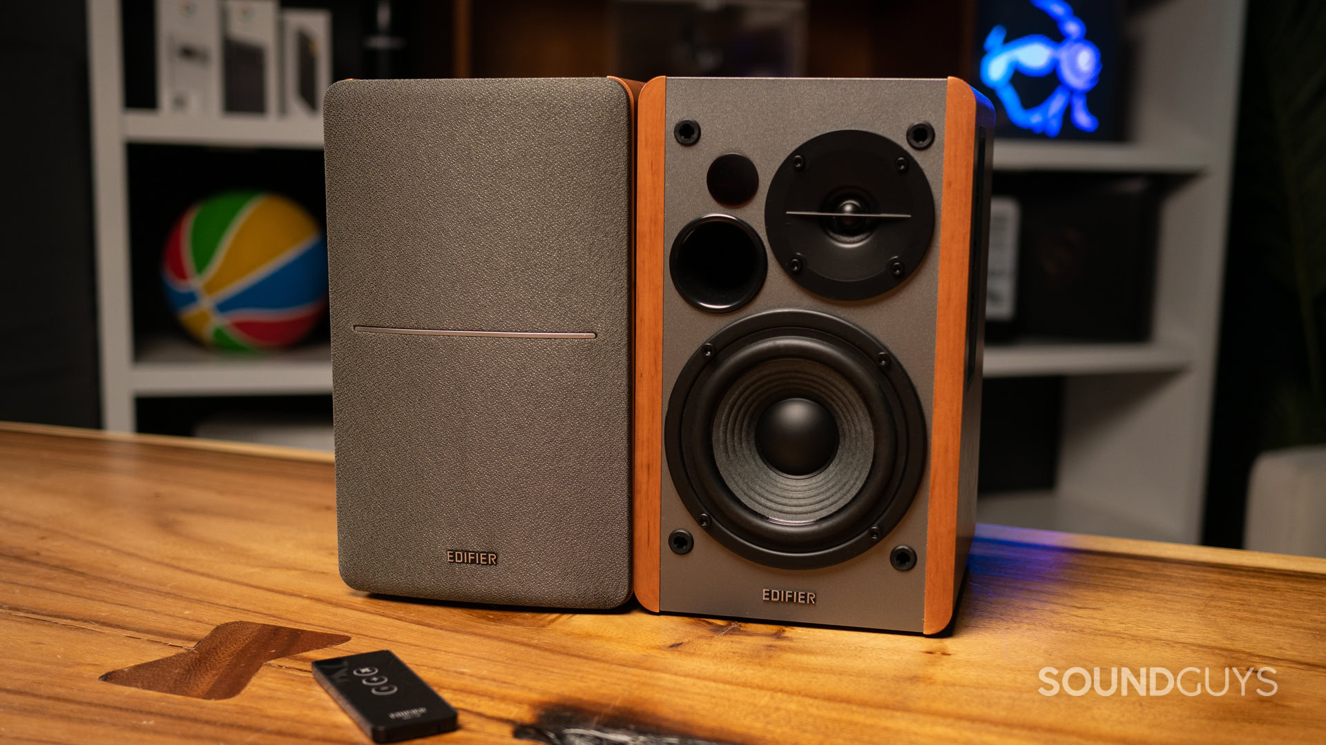 A photo of the Edifier R1280T sitting atop a wooden desk, with a remote in front of it.