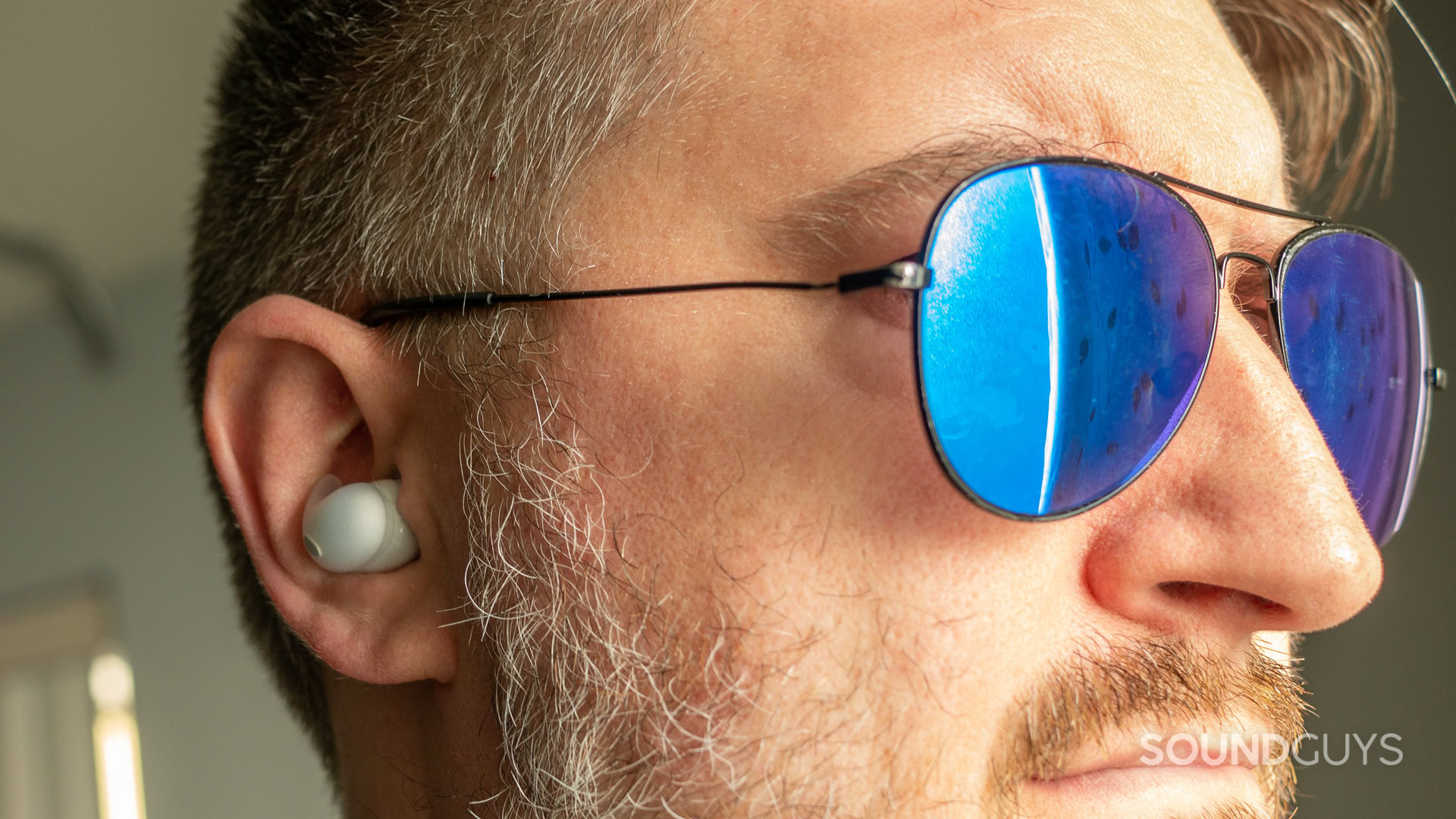 A photo of a man wearing sunglasses and the Sony LinkBuds fit.