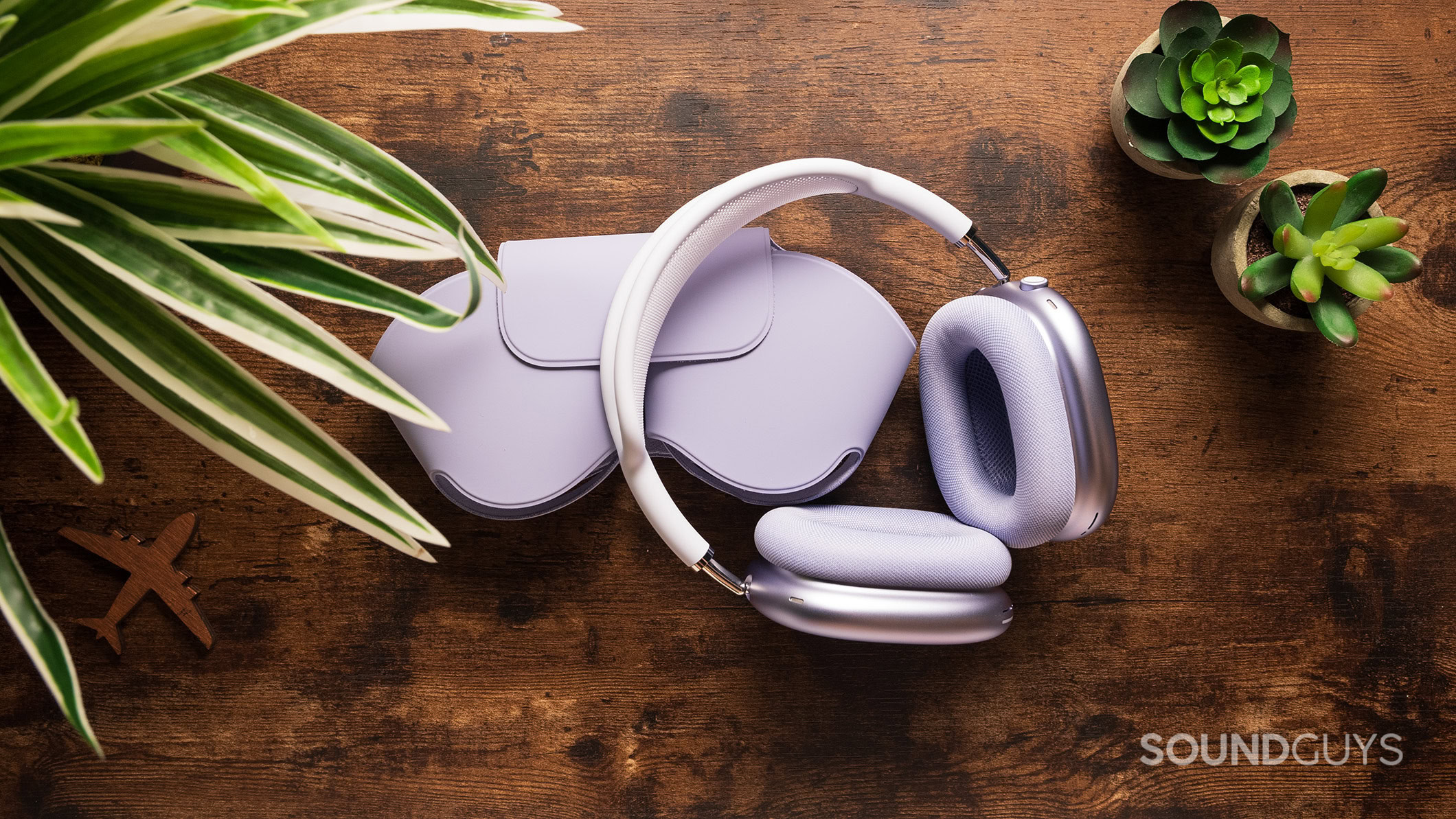 Purple AirPods Max headphones next to their case.