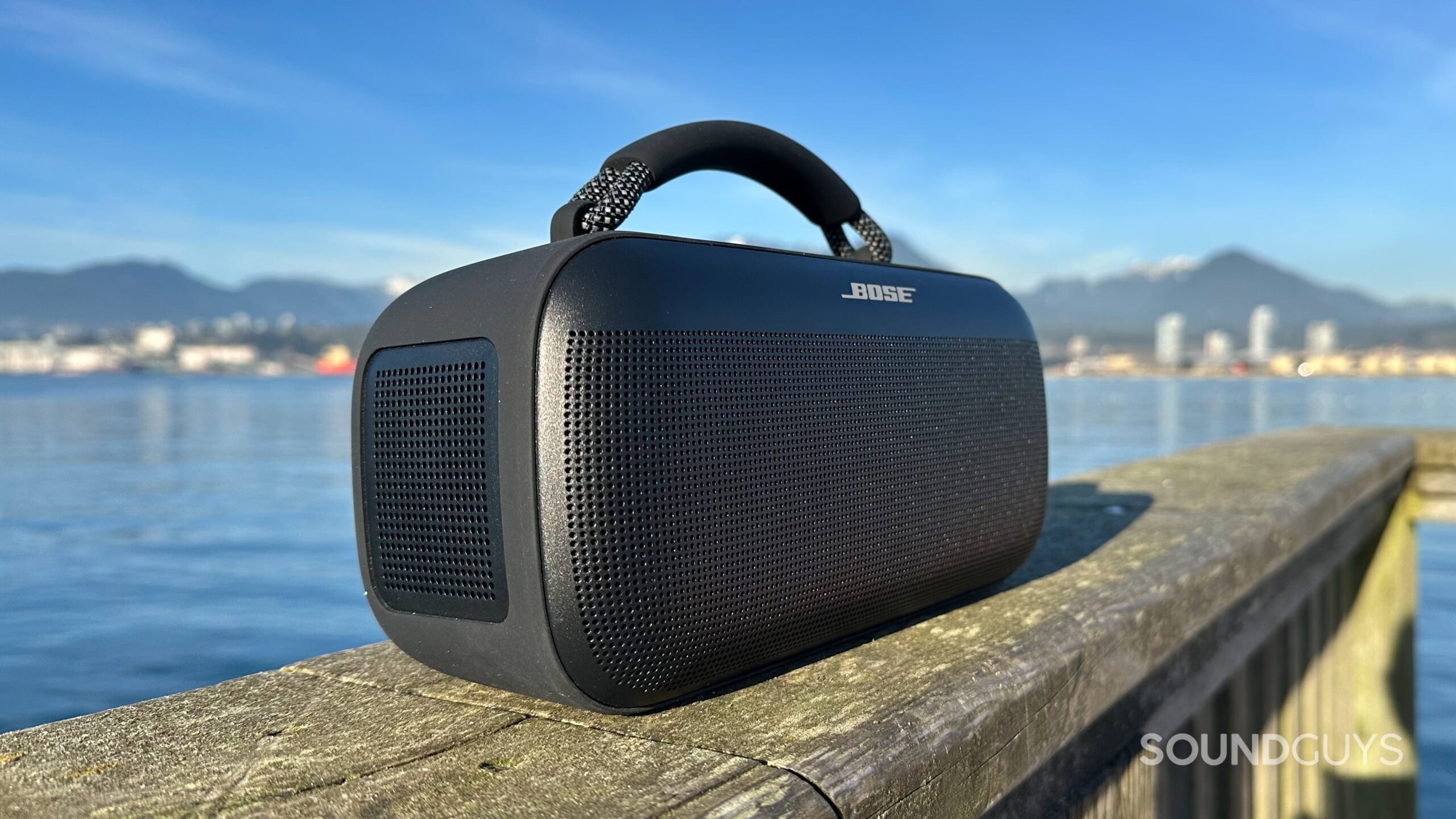 Bose SoundLink Max on a pier, focusing on its passive radiators.