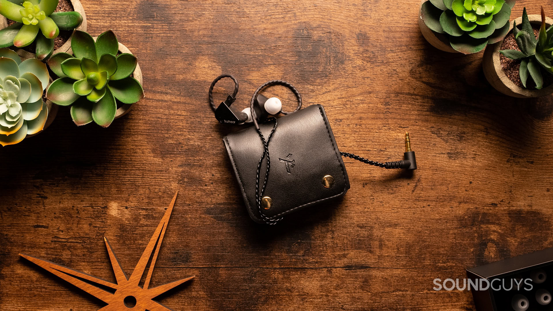 A photo of the Truthear Hexa in thier pouch, atop a wooden desk.