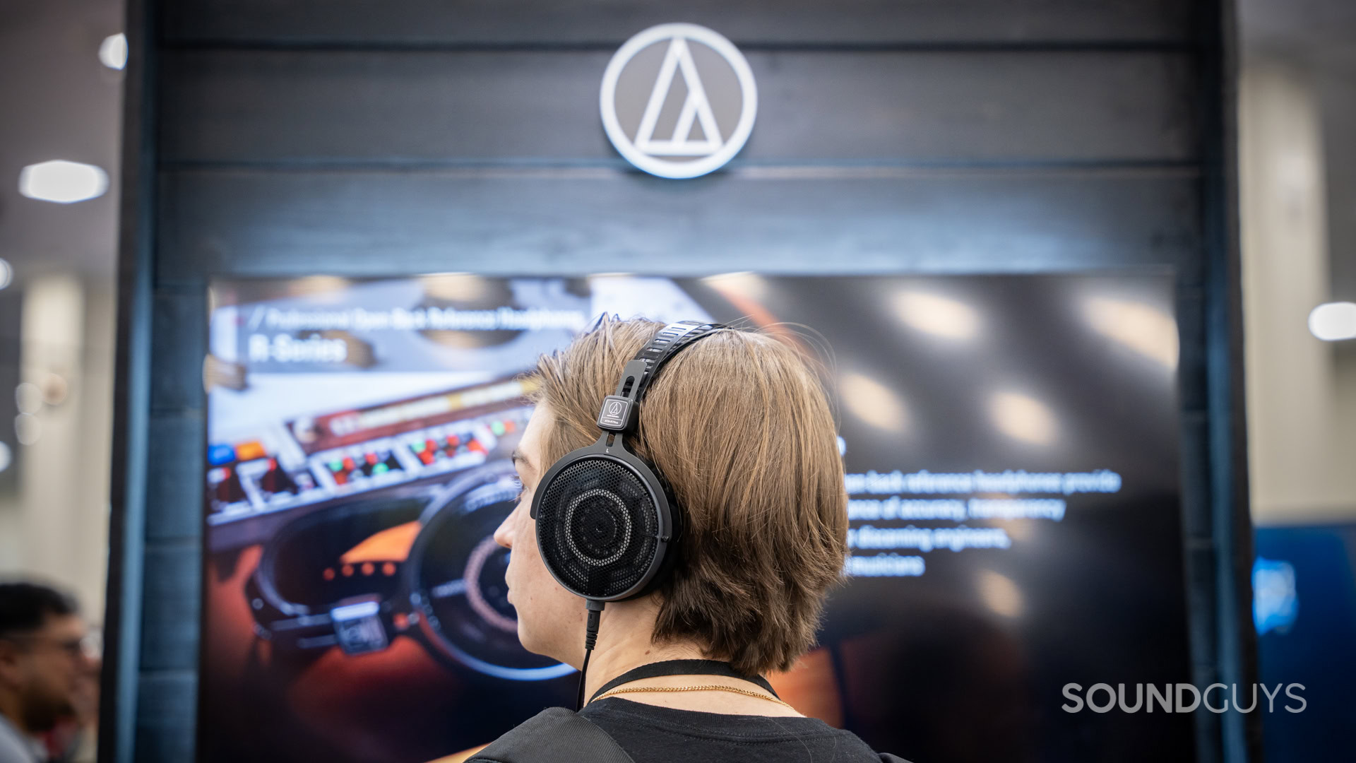 A man wearing Audio Technica ATH-R70xa open back headphones.