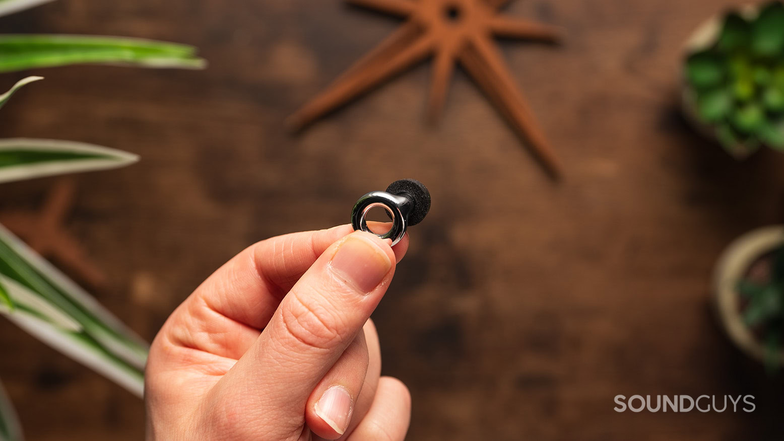 A hand holds the Loop Experience 2 earplug.