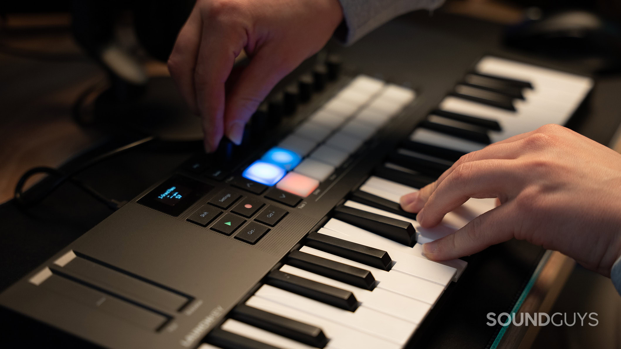 Hands playing the Novation Launchkey Mini 37 MK4 keyboard.