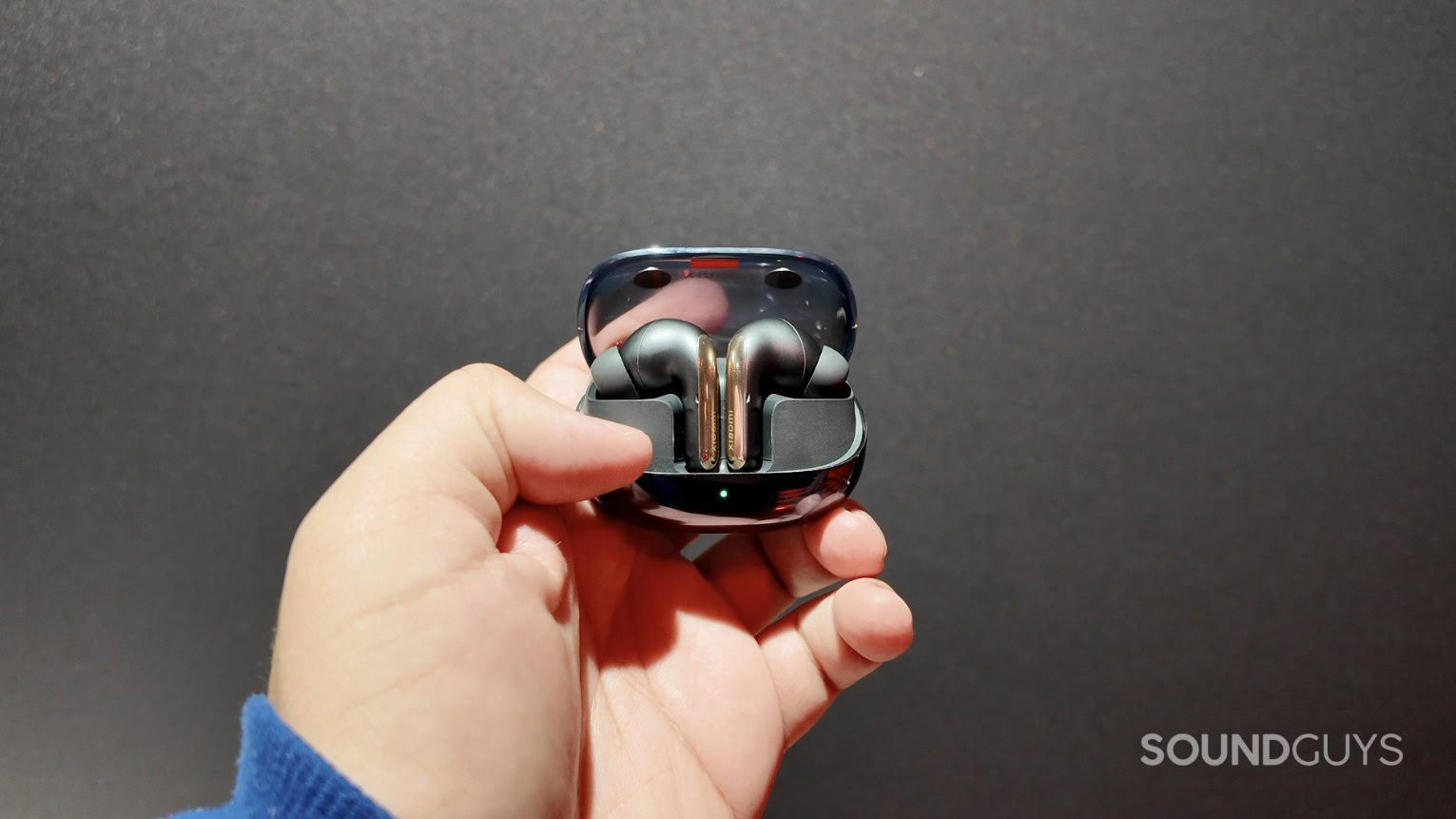 A hand holds the Xiaomi Buds 5 Pro.